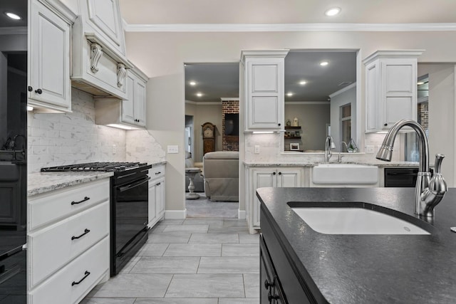 kitchen with tasteful backsplash, sink, white cabinets, ornamental molding, and black gas stove