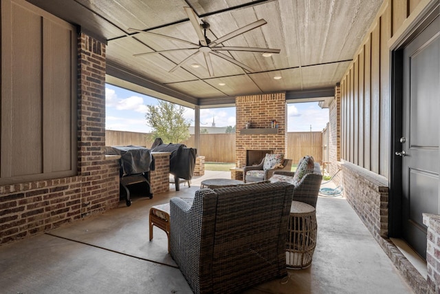 view of patio with an outdoor brick fireplace, area for grilling, and ceiling fan