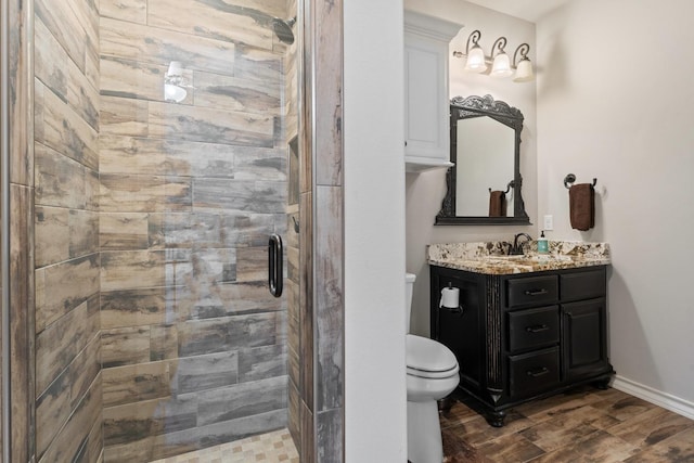 bathroom with vanity, tiled shower, and toilet