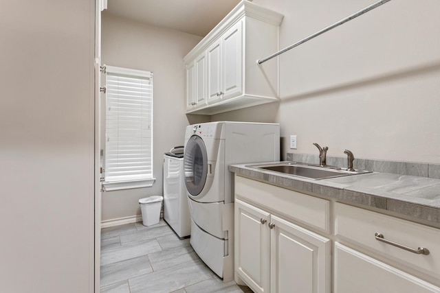 laundry room featuring cabinets, sink, and washer and clothes dryer