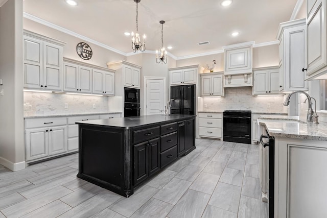 kitchen featuring sink, white cabinetry, tasteful backsplash, a kitchen island, and black appliances