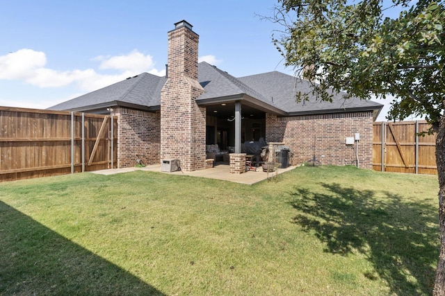 rear view of house with a yard and a patio area