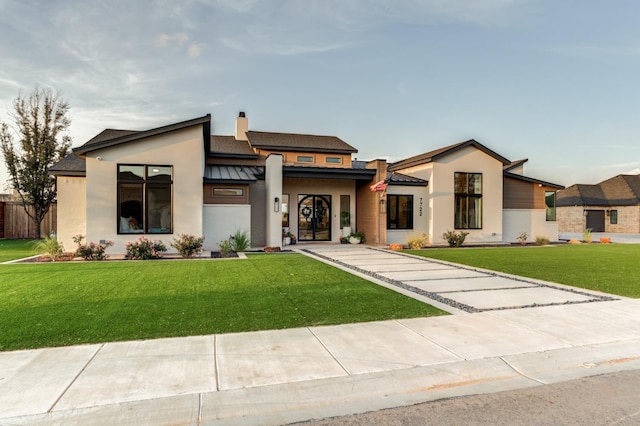 7722 47th St, Lubbock, TX 79407 - modern home featuring a standing seam roof, stucco siding, a front yard, and a metal roof