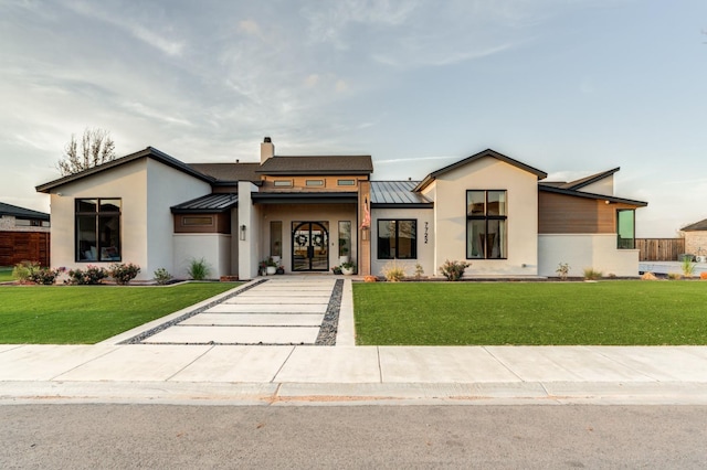 7722 47th St, Lubbock, TX 79407 - view of front of house with a standing seam roof, a metal roof, stucco siding, and a front lawn