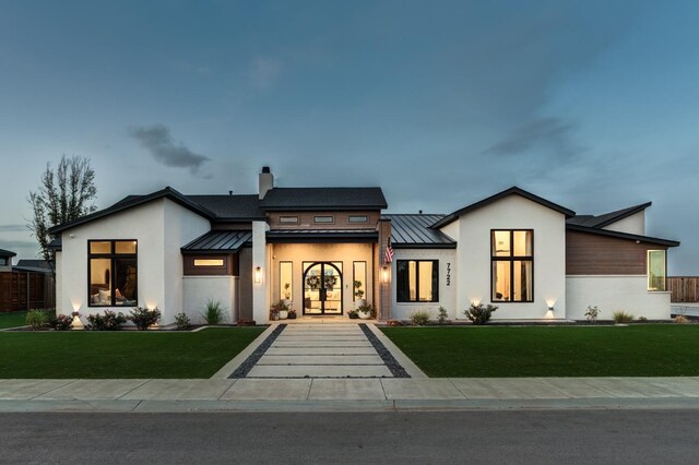 7722 47th St, Lubbock, TX 79407 - view of front of home featuring a standing seam roof, a metal roof, stucco siding, and a front lawn