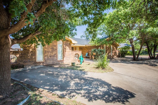 exterior space featuring concrete driveway and brick siding