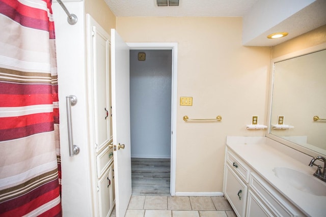 bathroom with vanity, tile patterned floors, and a textured ceiling