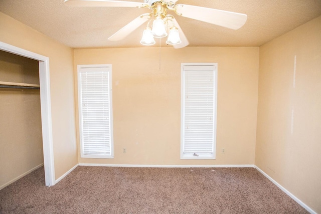 unfurnished bedroom featuring ceiling fan, carpet floors, and a textured ceiling