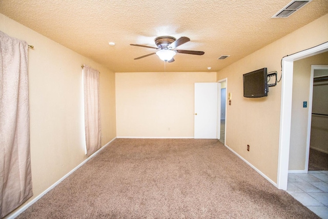 unfurnished room featuring ceiling fan, carpet flooring, and a textured ceiling