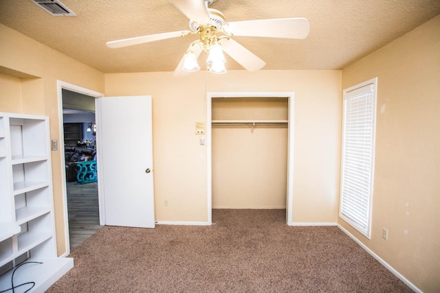 unfurnished bedroom featuring ceiling fan, a closet, a textured ceiling, and carpet