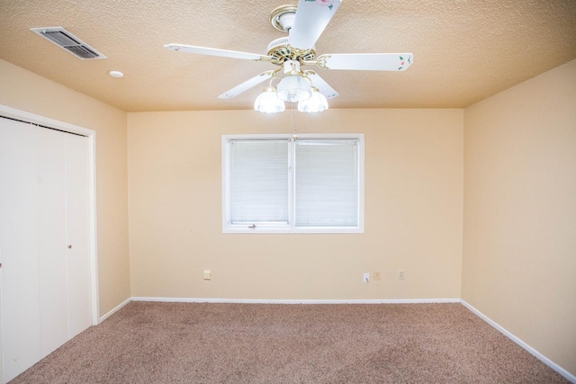 unfurnished bedroom featuring ceiling fan, carpet flooring, a closet, and a textured ceiling