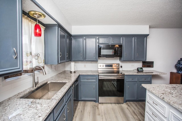 kitchen with sink, light stone counters, light wood-type flooring, decorative backsplash, and black appliances