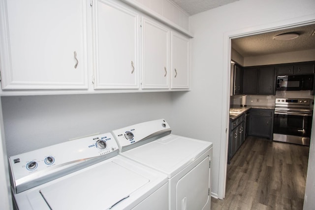 clothes washing area with dark hardwood / wood-style floors, washer and clothes dryer, and a textured ceiling