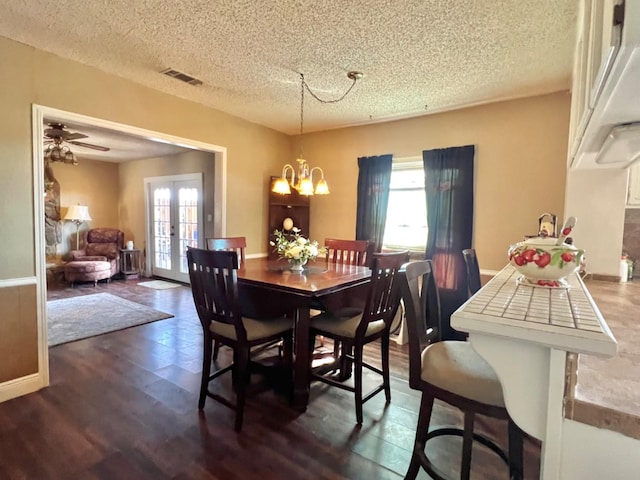 dining area featuring french doors, a chandelier, dark wood-type flooring, and a wealth of natural light