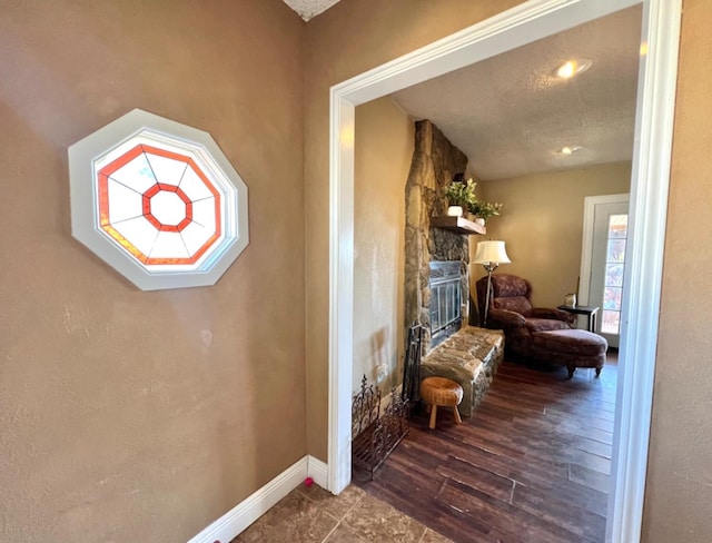 hall featuring dark wood-type flooring and a textured ceiling