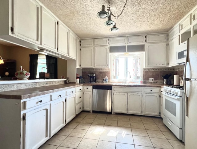 kitchen featuring white cabinetry, sink, white appliances, and light tile patterned flooring