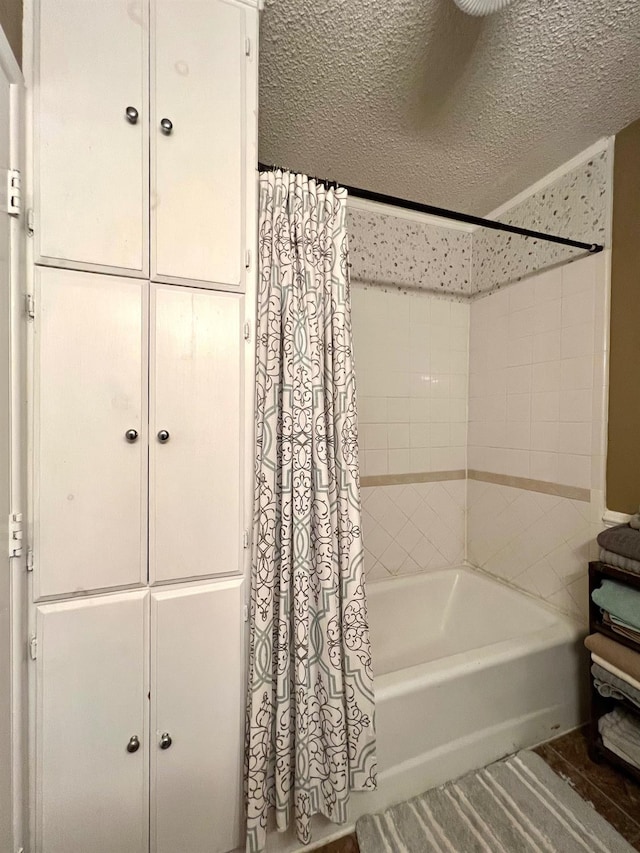 bathroom featuring shower / tub combo with curtain and a textured ceiling