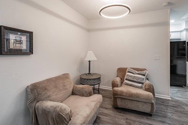 living area featuring ornamental molding, dark hardwood / wood-style floors, and a textured ceiling