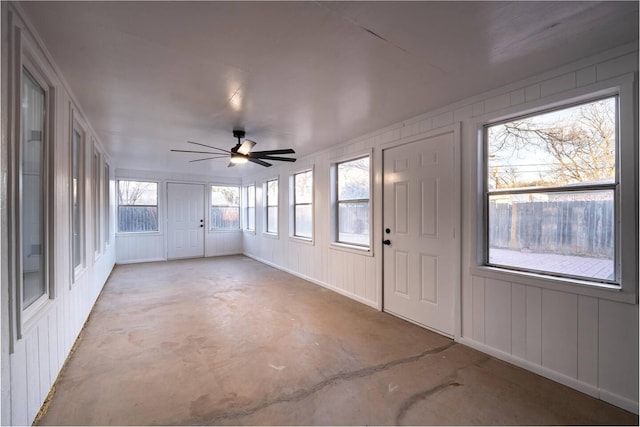 unfurnished sunroom with ceiling fan