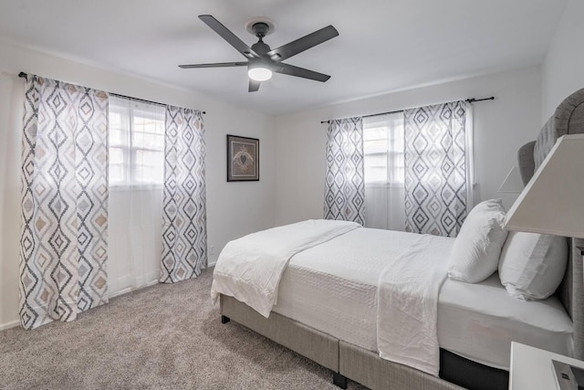 carpeted bedroom featuring multiple windows and ceiling fan