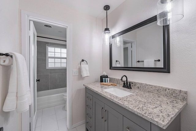 full bathroom with tile patterned flooring, vanity, tiled shower / bath, and toilet