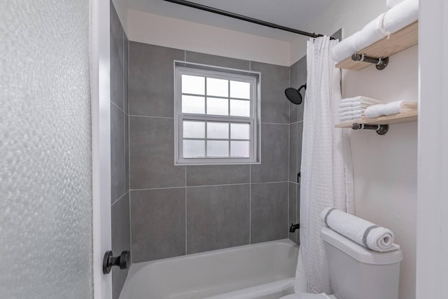 bathroom featuring shower / tub combo and toilet