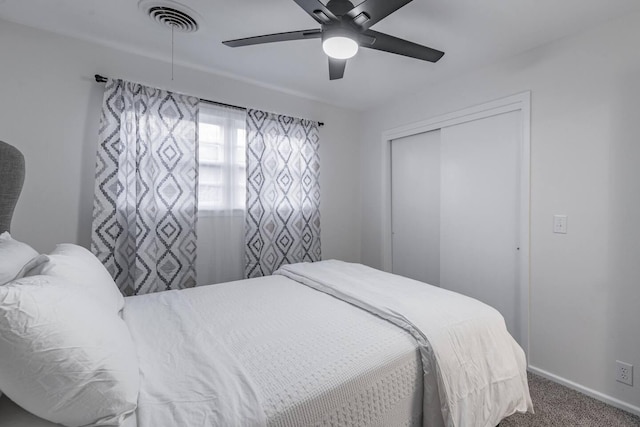 carpeted bedroom featuring ceiling fan and a closet