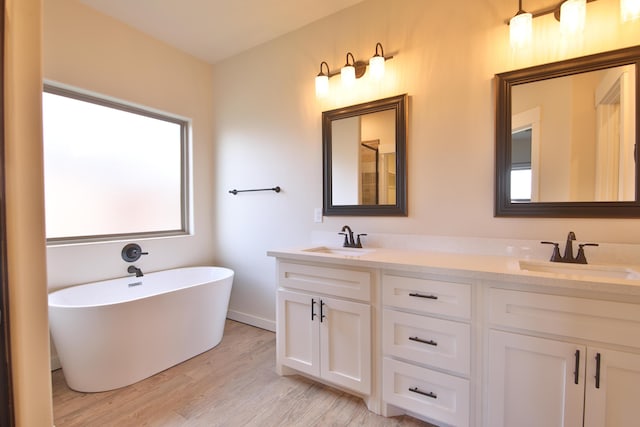 10504 Ave X, Lubbock, TX 79423 - bathroom featuring double vanity, wood finished floors, and a freestanding tub