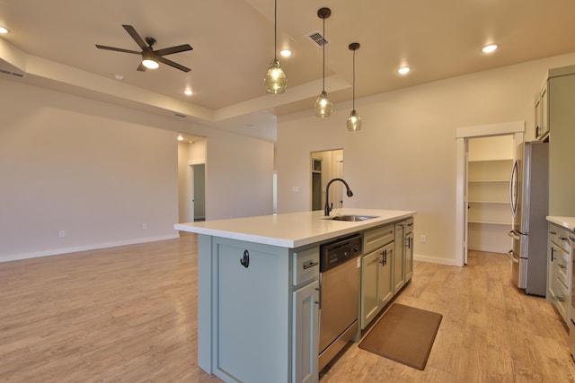 10504 Ave X, Lubbock, TX 79423 - kitchen featuring stainless steel appliances, a ceiling fan, a kitchen island with sink, light countertops, and light wood-style floors
