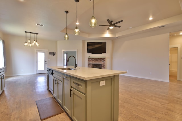 10504 Ave X, Lubbock, TX 79423 - kitchen featuring open floor plan, ceiling fan, light countertops, a fireplace, and light wood-style floors