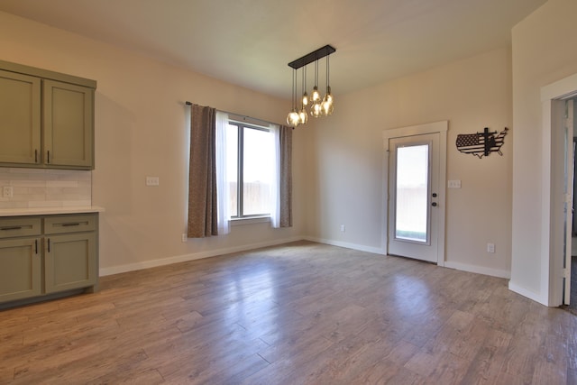 10504 Ave X, Lubbock, TX 79423 - unfurnished dining area featuring light wood-style flooring and a chandelier