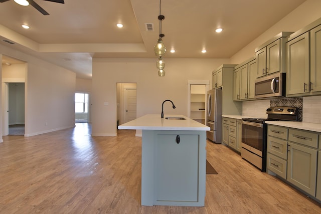 10504 Ave X, Lubbock, TX 79423 - kitchen featuring stainless steel appliances, backsplash, an island with sink, a raised ceiling, and ceiling fan