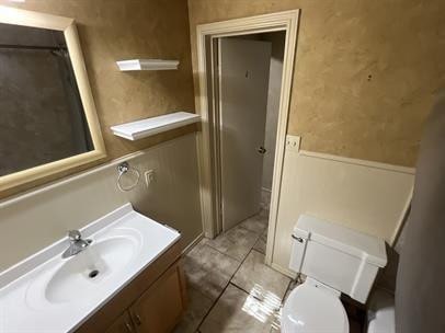 bathroom featuring walk in shower, tile patterned floors, vanity, and toilet