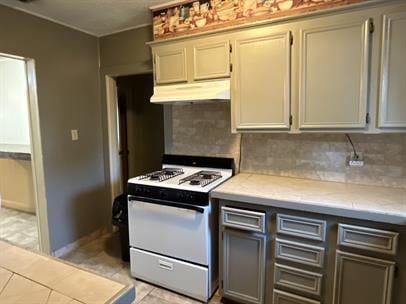 kitchen featuring gray cabinetry, decorative backsplash, and white range with gas stovetop