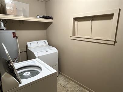 washroom with light tile patterned floors, washer and clothes dryer, and water heater