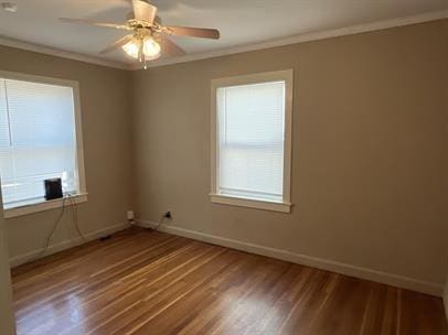 empty room with hardwood / wood-style flooring, ceiling fan, and crown molding