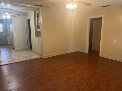 empty room featuring dark wood-type flooring and ceiling fan