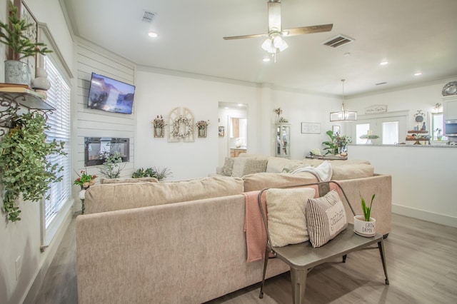 living room featuring crown molding, ceiling fan, and hardwood / wood-style floors