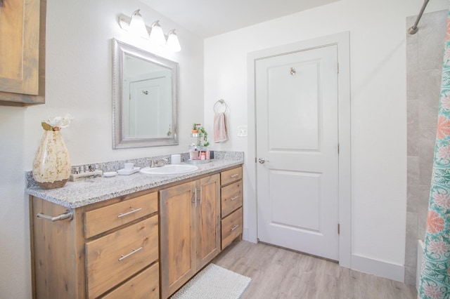 bathroom featuring vanity, wood-type flooring, and walk in shower