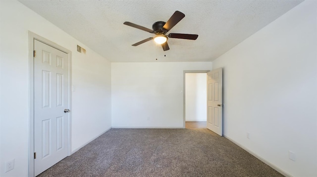 carpeted empty room with ceiling fan and a textured ceiling