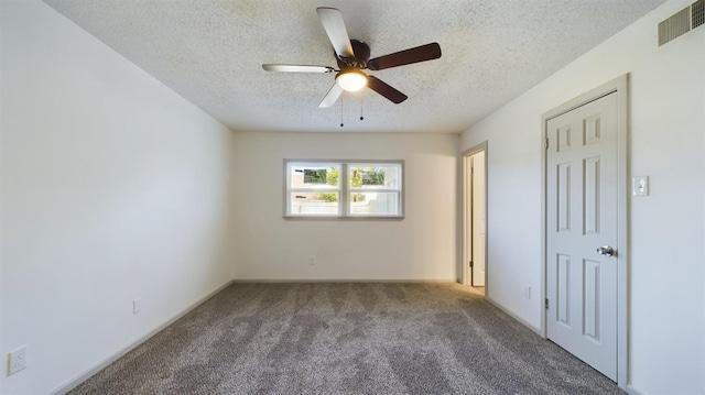 unfurnished room featuring ceiling fan, carpet, and a textured ceiling