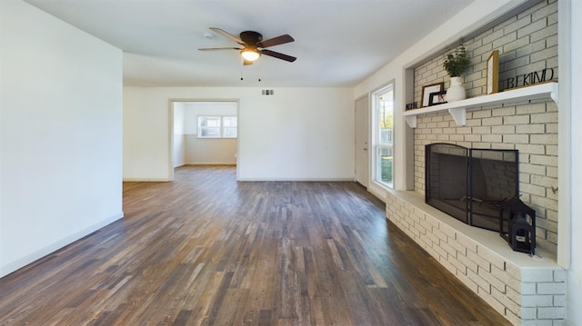 unfurnished living room with dark hardwood / wood-style flooring, ceiling fan, and a fireplace