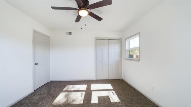 unfurnished bedroom featuring dark carpet, ceiling fan, and a closet