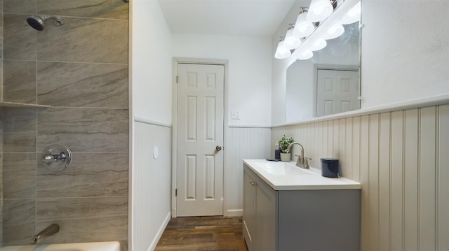 bathroom with vanity, wood-type flooring, and tiled shower / bath