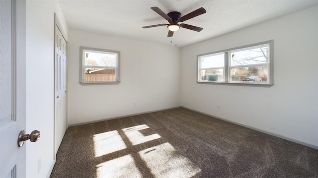 carpeted spare room with a wealth of natural light and ceiling fan