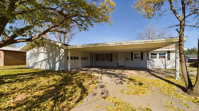 ranch-style home with a garage, a front lawn, and a carport