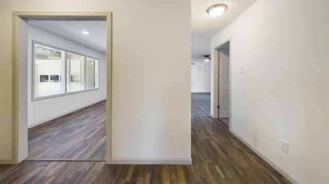 hallway featuring dark wood-type flooring and a textured ceiling