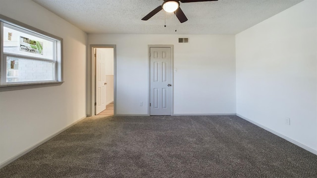 spare room featuring ceiling fan, a textured ceiling, and carpet flooring