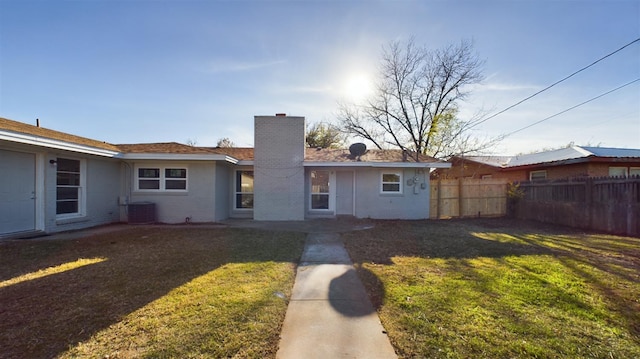 rear view of property featuring a yard and central AC