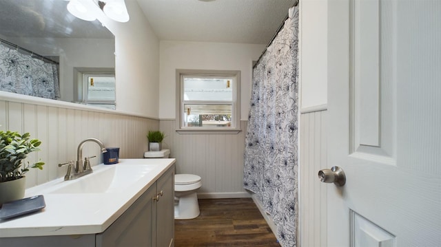 bathroom with vanity, wood-type flooring, a textured ceiling, a shower with curtain, and toilet